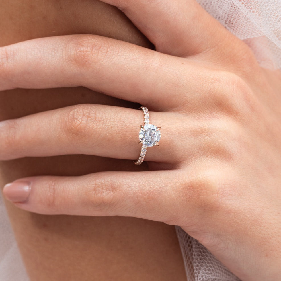 Rose - Micheli Jewellery, Diamond Engagement Ring, Rose Gold Engagement Ring with Round Brilliant Cut Centre Stone with 4 flaws and a Diamond Pave Band on hand. Diamond Engagement Ring modelled on hand. Rose gold Engagement Ring. Rose gold engagement ring on hand.