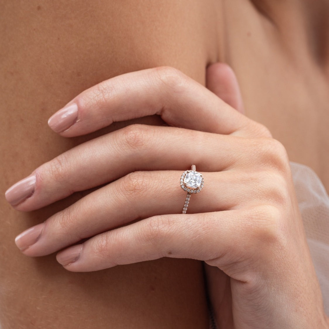 Rebecca - Micheli Jewellery, rose gold engagement ring with cushion cut diamond modelled on hand. engagement ring on hand. diamond band and halo engagement ring on hand.