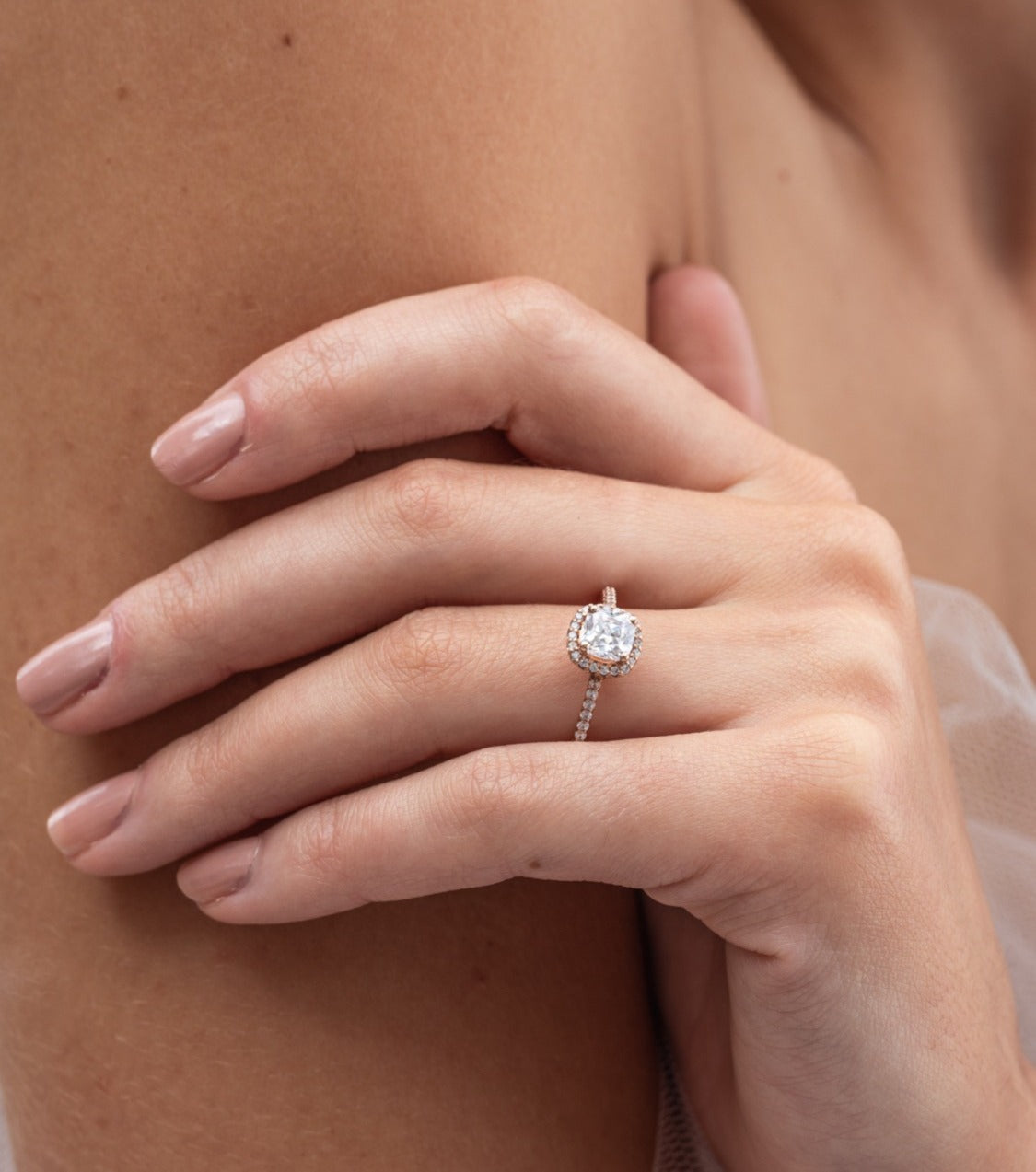 Rebecca - Micheli Jewellery, rose gold engagement ring with cushion cut diamond modelled on hand. engagement ring on hand. diamond band and halo engagement ring on hand.